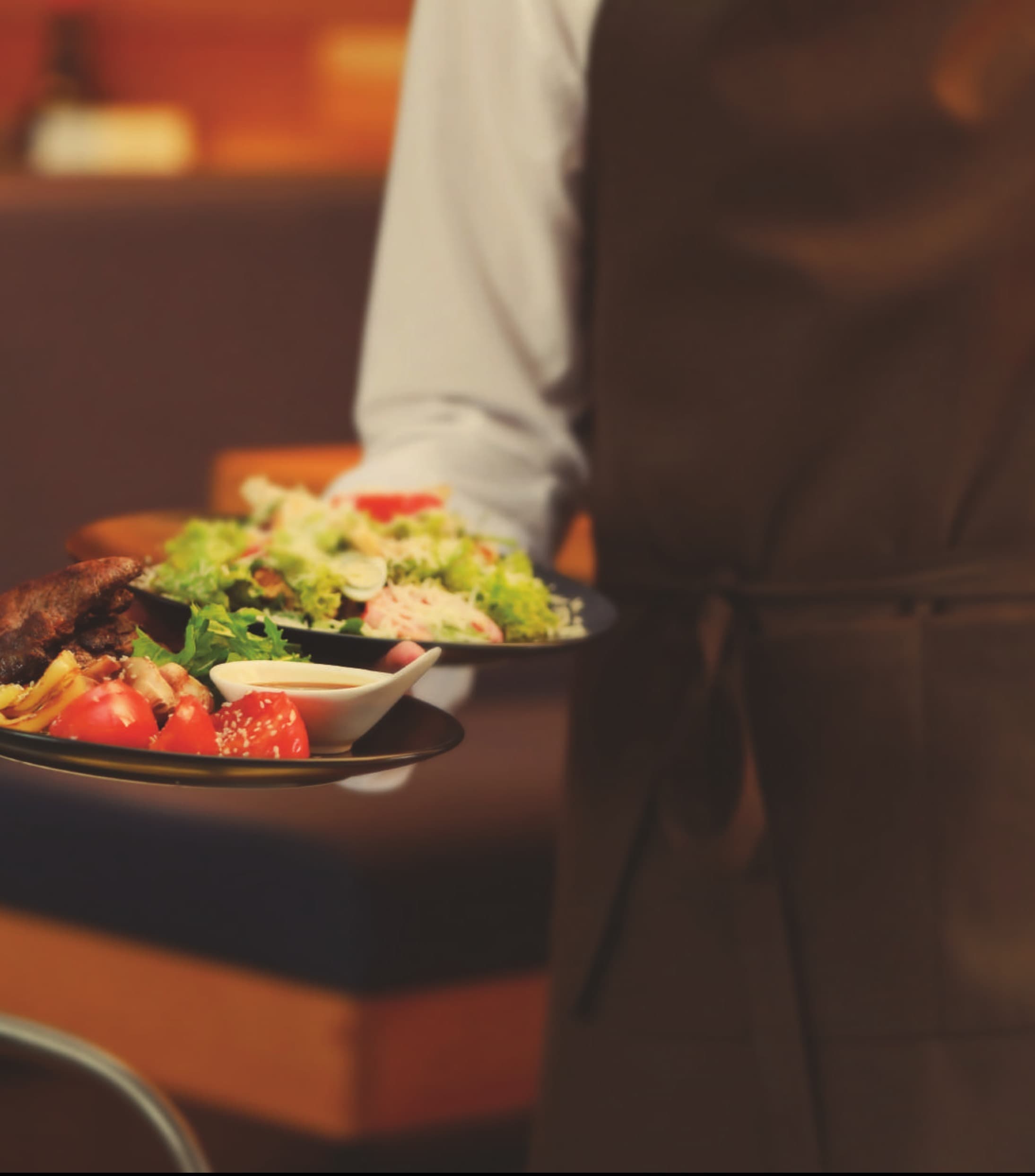 A chef carrying freshly plated salads through the ISFC kitchen